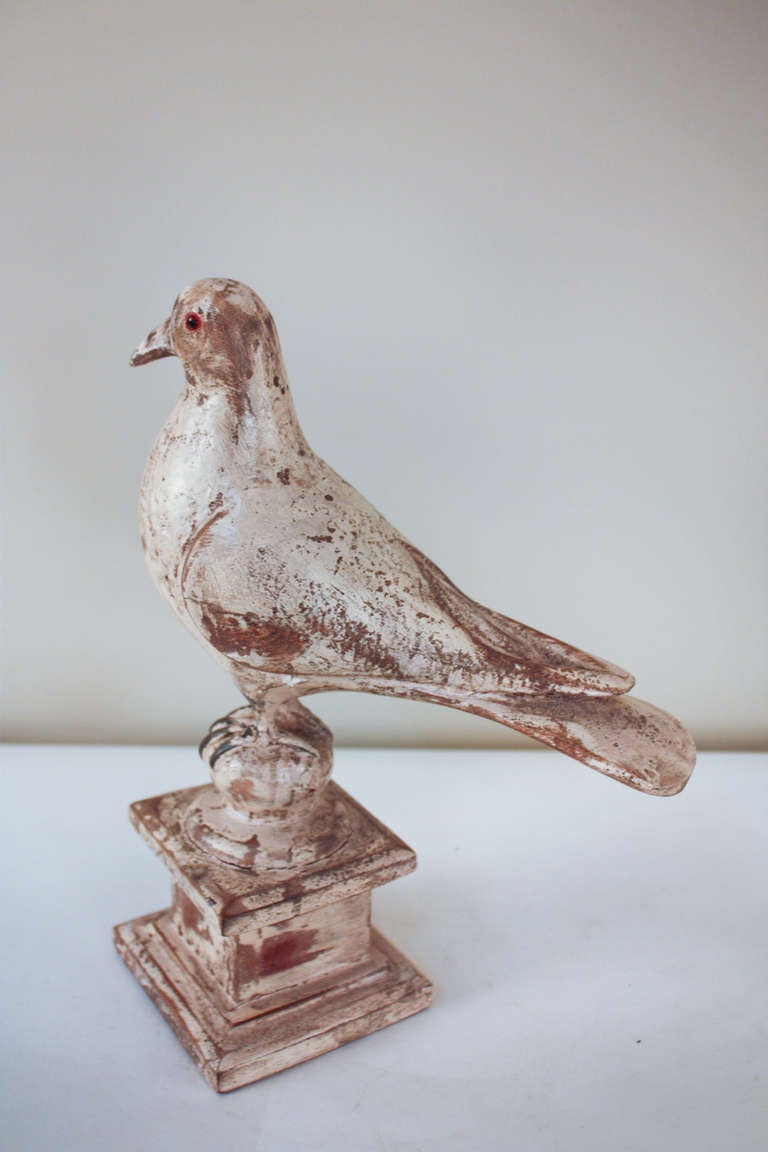 A beautiful handmade statue. Originally made in Spain at the turn of the last century, this wooden hand carved bird is a true work of art. This carving is in its original condition with a distressed finish. Artisanally made glass eyes give this