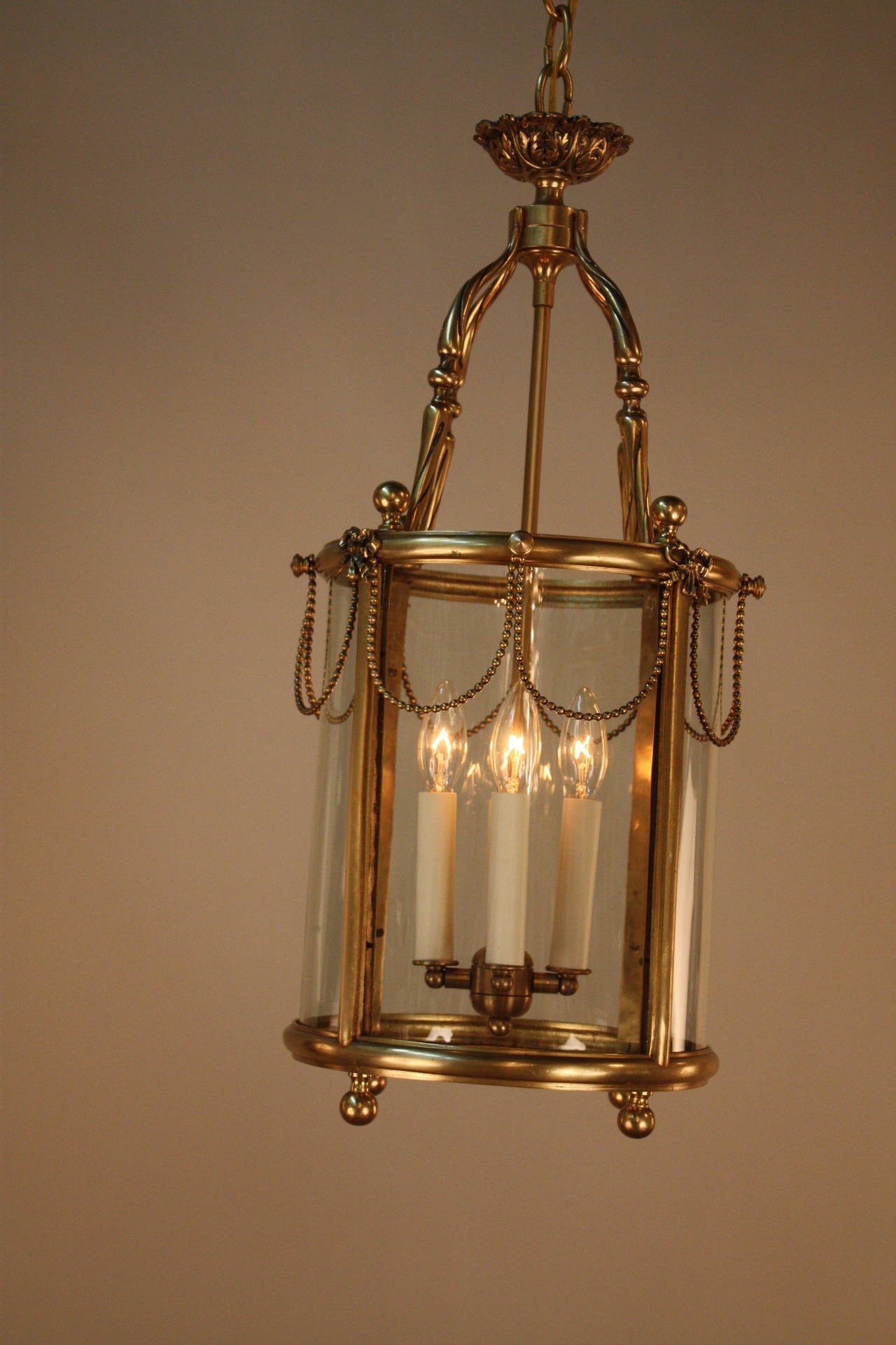 A simple yet elegant four-light fixture. Crafted in France during the 1930s, this hanging lantern features a Classic bronze design.
