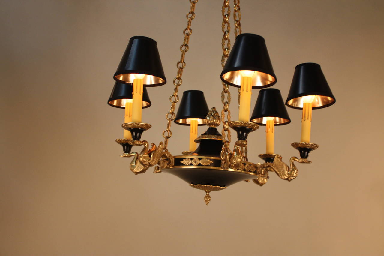 Made in France during the 1930s, this gorgeous six-light chandelier is made in the Classic Empire style. Traditional bronze, filled with incredible detail work, adorns the black lacquer body. This chandelier measures 23.5