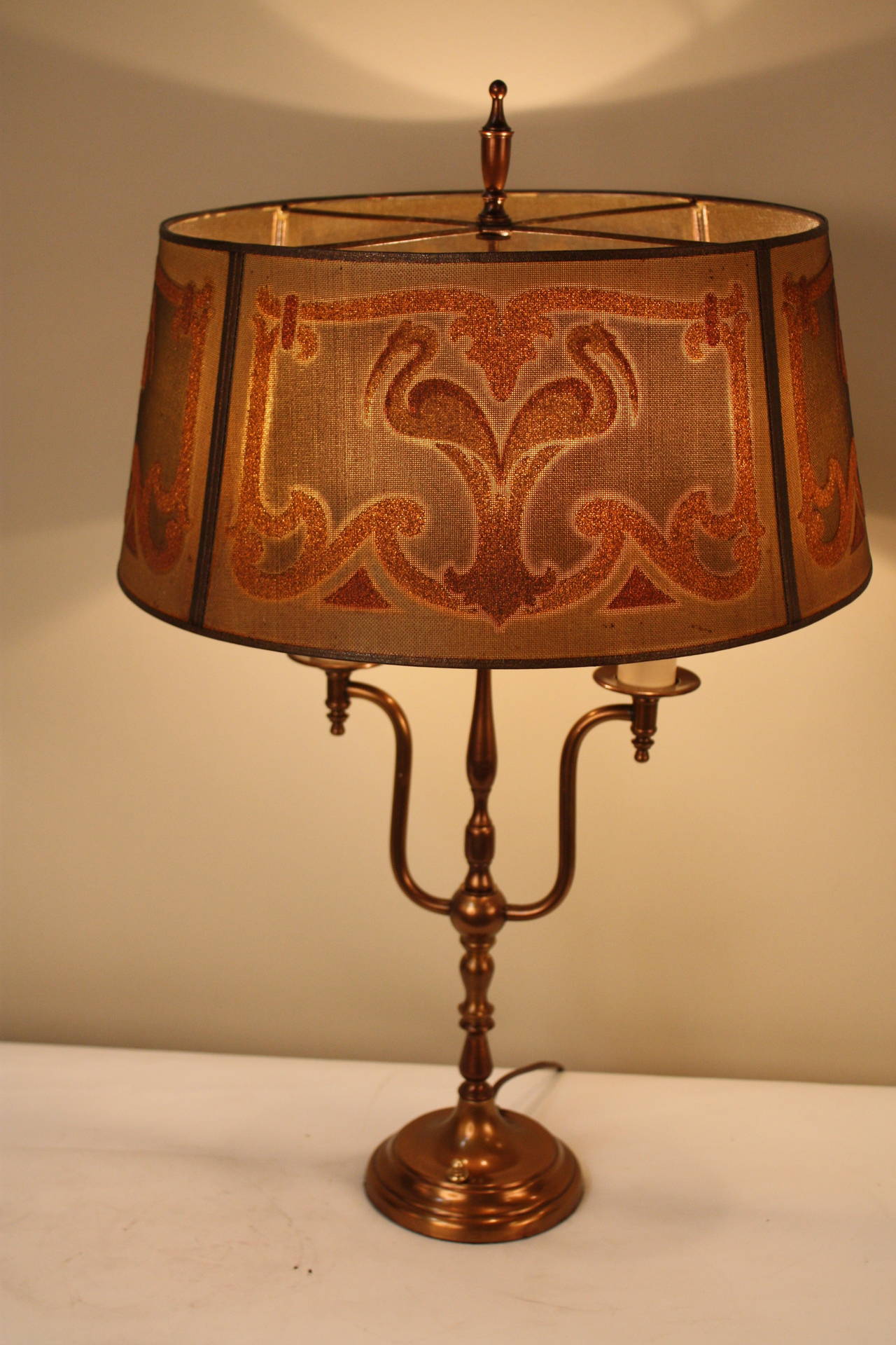 This wonderful 1930s table lamp is truly fabulous, featuring painted metal mesh shades and an antique finished brass base. The tapestry mesh shade is by the Mutual Sunset Lamp Co. of New York. A Classic American lamp maker. 
The diameter is 16.25
