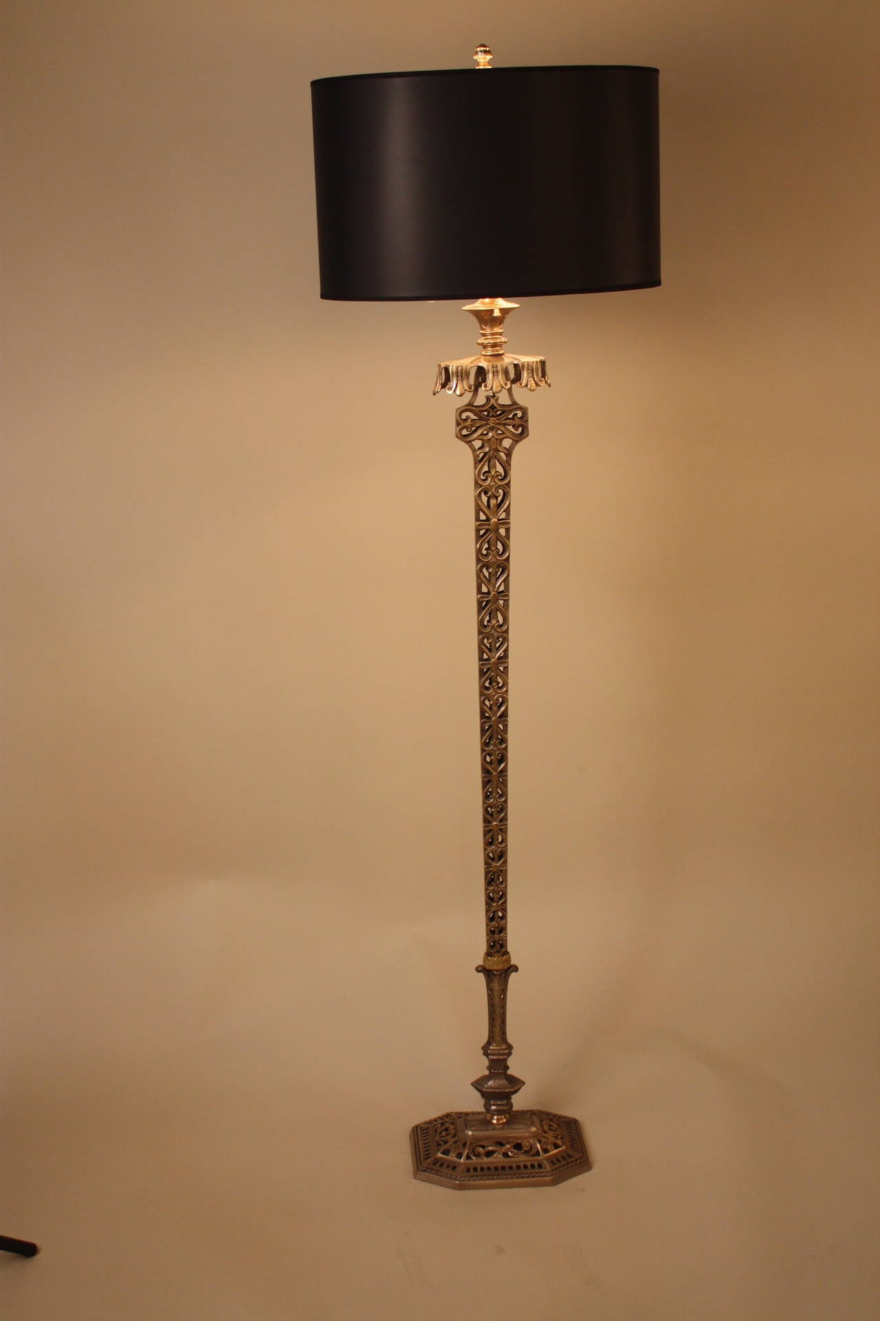 An unusually designed American floor lamp with oblong column that is wide at top and gets narrow at the base. The column is a two tone colored oxidized nickel with highlights of soft brushed shinny brass. This lamp is fitted with a silver-lined oval