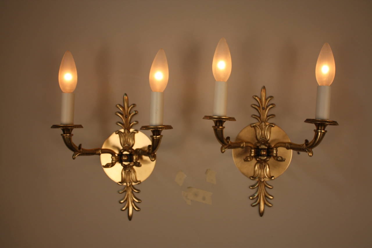 An elegant pair of Classic bronze wall sconces. Artisanally crafted in France during the 1930s, these gorgeous sconces feature fabulous bronze work: Beautiful examples of fantastic traditional European artistry and craftsmanship.