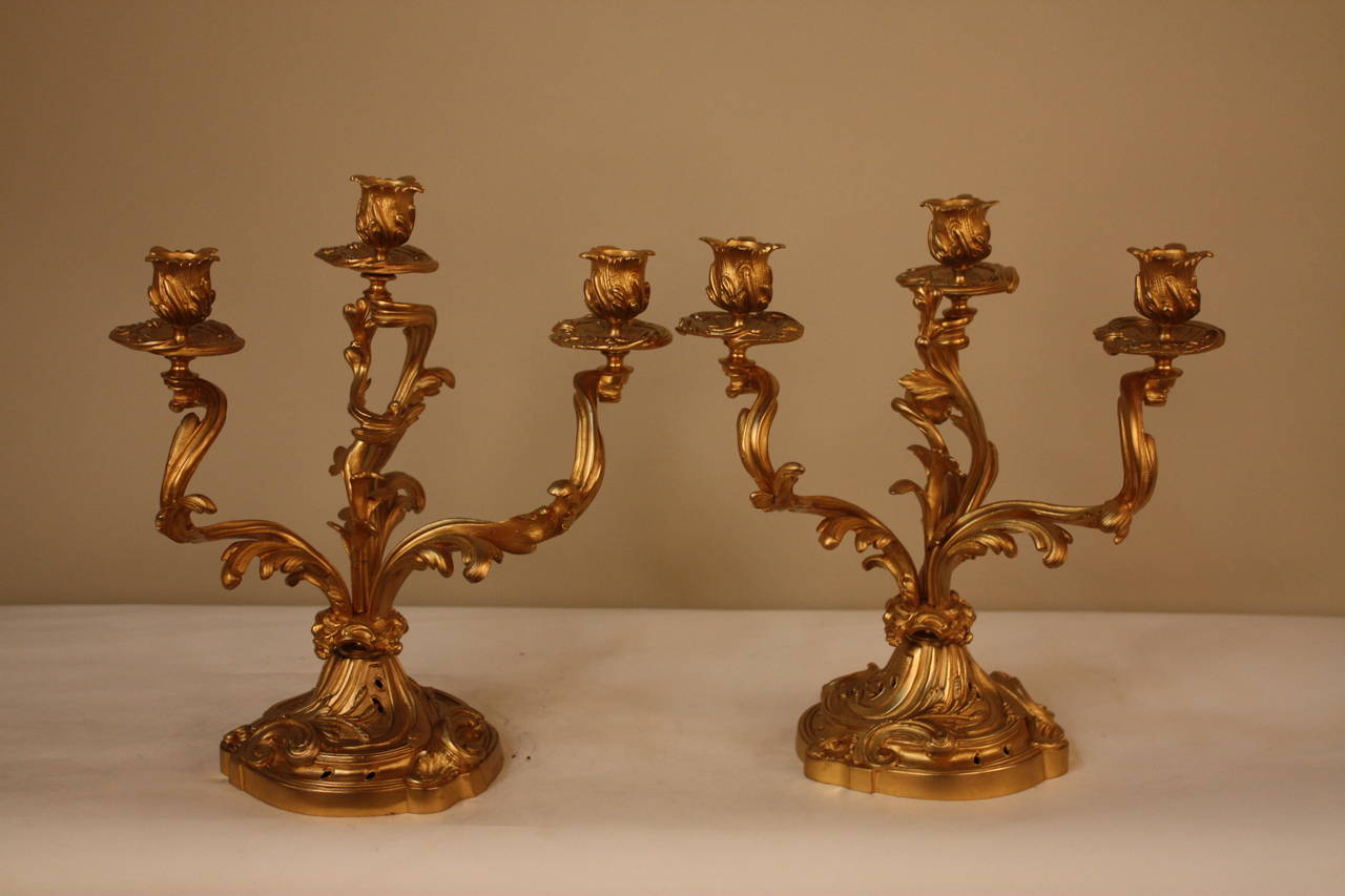 An elegant pair of early 20th century candelabrum. Crafted in France and made of bronze, these three-arm candelabra are absolutely beautiful.
