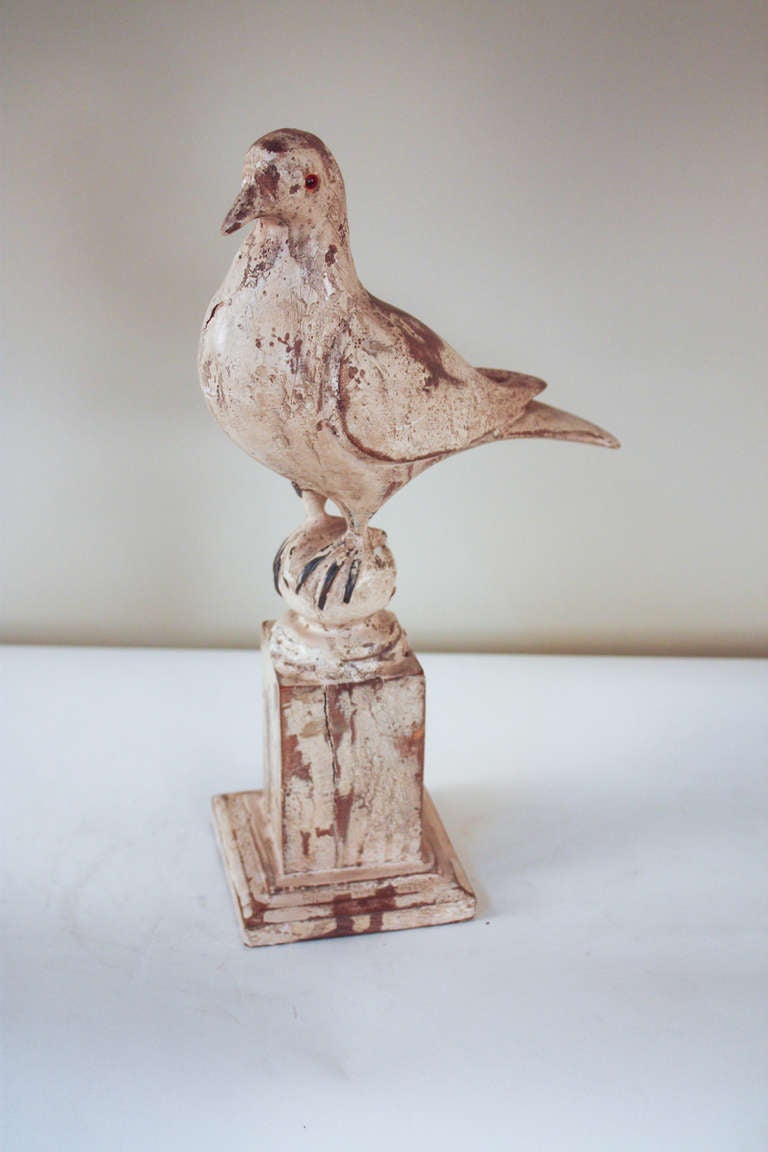 A beautiful handmade statue. Originally made in Spain at the turn of the last century, this wooden hand carved bird is a true work of art. This carving is in its original condition with a distressed finish. Artisanally made glass eyes give this