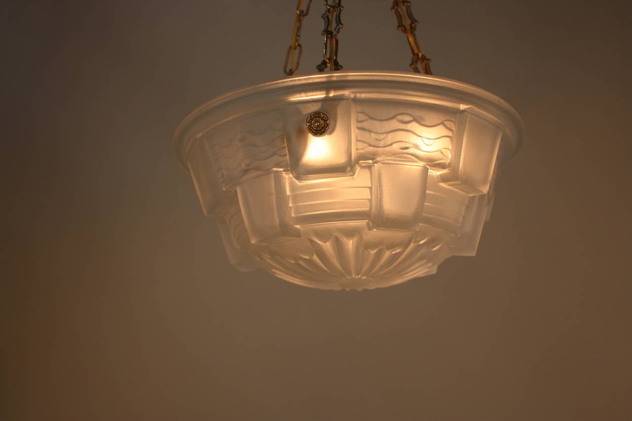 A beautiful French Art Deco pendant light. Made of glass and bronze chain and canopy.