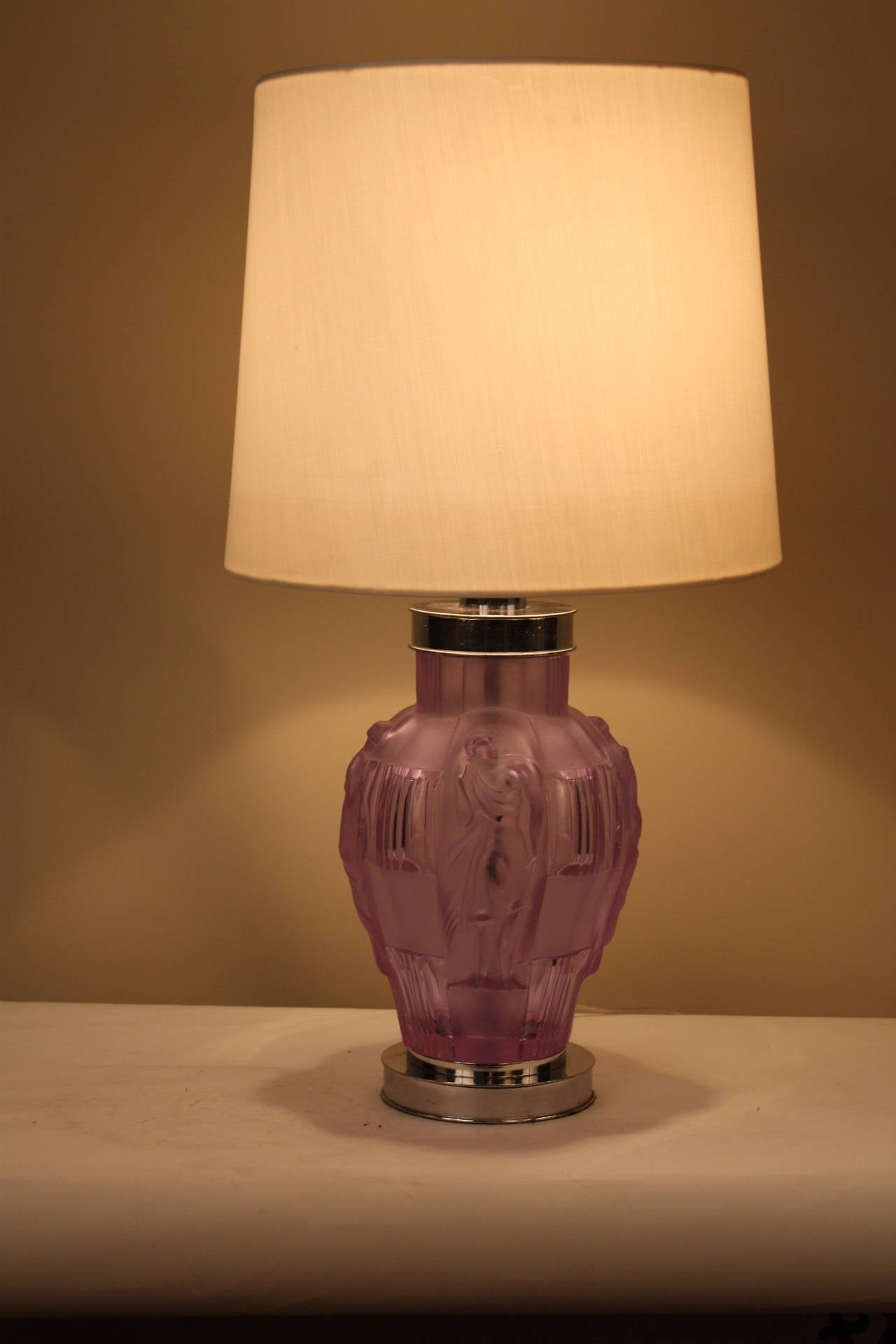 A beautiful and unique table lamp. Made of satin and acid finished light purple color glass, the surface is both frosted and highly polished with four semi-nude women, giving the fogged glass translucent highlights.