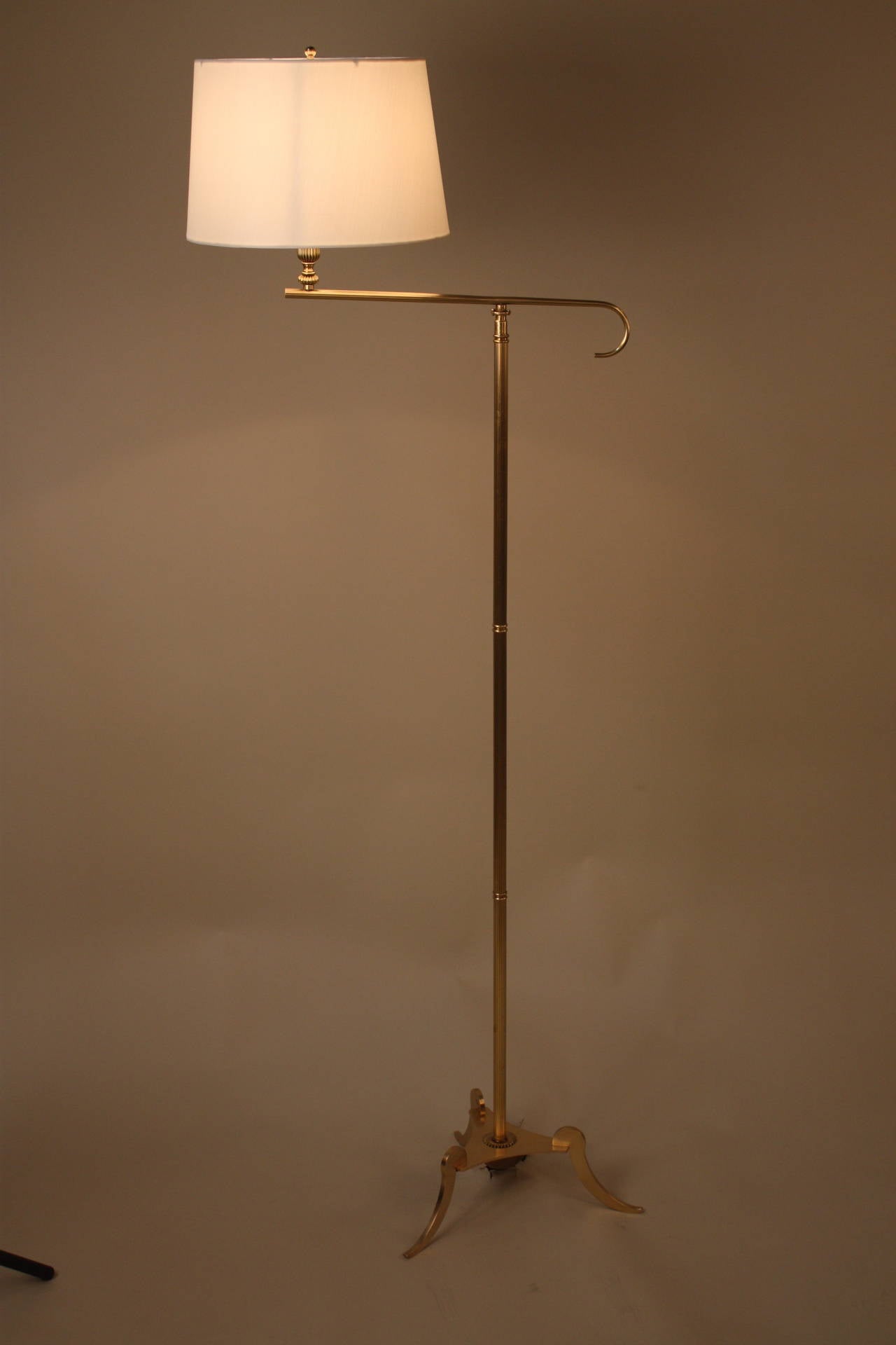 An exceptional Mid-Century bronze floor lamp with graceful tripod base and 180 swing arm.