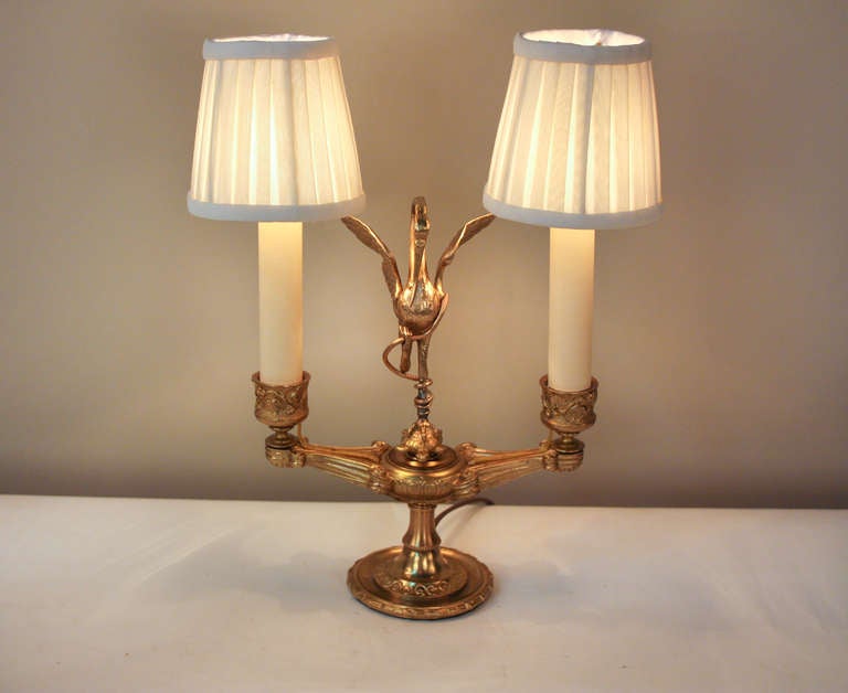 Originally used as traditional candelabra during the 1800's in France, this once candle burning piece has been lovingly custom converted and electrified; resulting in a beautiful two light table lamp. Made of ornately detailed bronze, this elegant