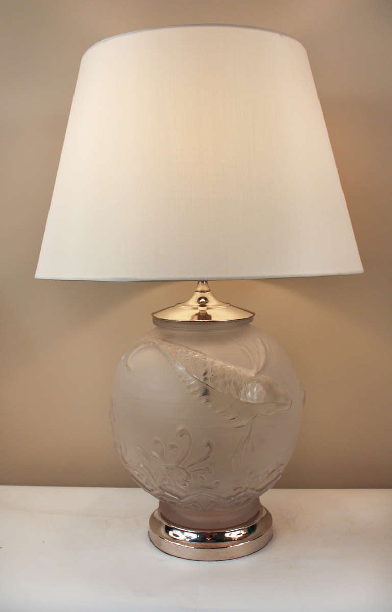 A beautiful and unique table lamp. Made of satin and acid finished glass, the surface is both frosted and highly polished, giving the fogged glass translucent highlights, spotlighting the beautiful swimming koi fish design. An elegant and serene