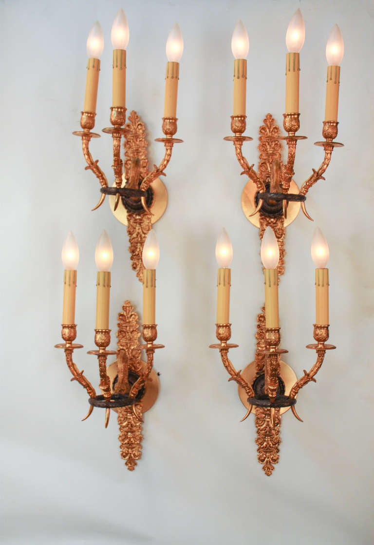 These gorgeous wall sconces are the definition of true elegance. Masterfully crafted in 19th c. France in the traditional Empire style; these fixtures are made of ornately detailed solid gilt bronze. Originally candle burning pieces, these sconces