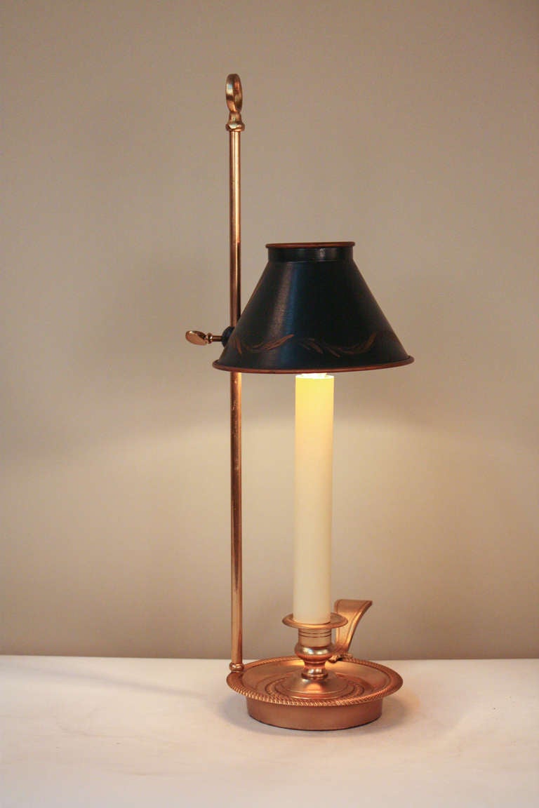 Made in France during the early 20th century, this artisanally crafted table lamp is truly beautiful. Made of gorgeous bronze in the Empire style, this single light table lamp features an adjustable height hand painted shade, creating an elegant and