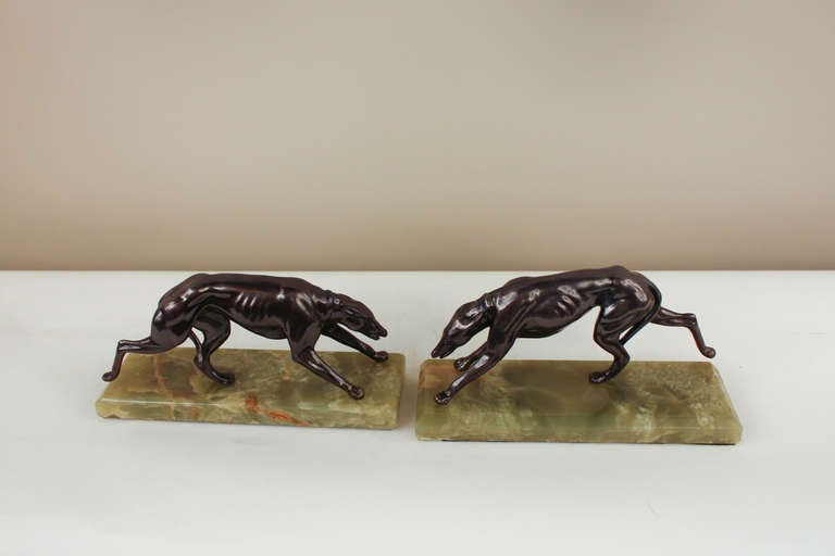 A beautiful pair of bookends. Made in France during the 1930's, these bookends feature a pair of lifelike greyhounds mid-sprint. Rendered in beautiful bronze on spelter, the greyhounds are mounted atop a gorgous green onyx base.
