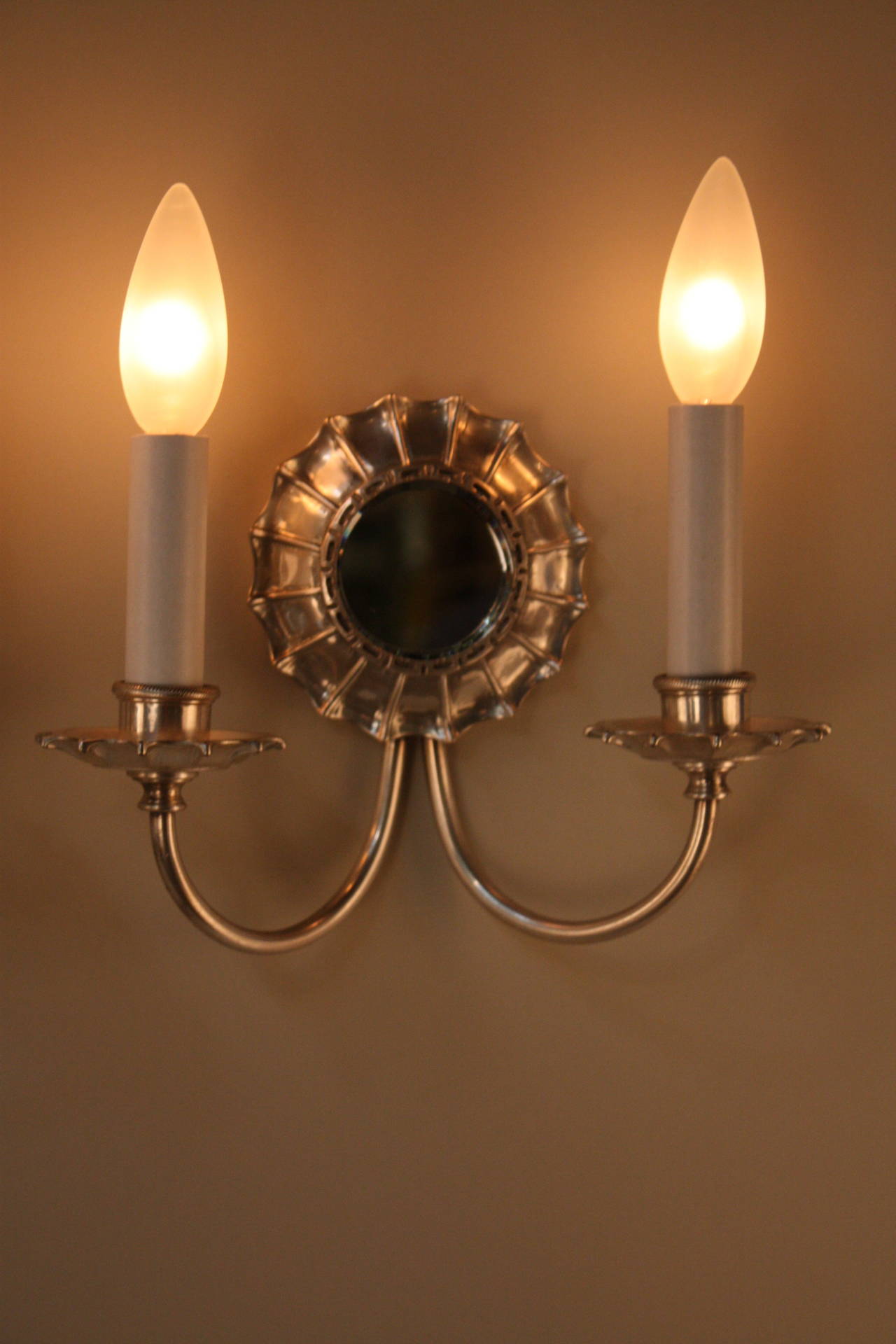 Silver on bronze wall sconces with a beveled mirror in the center. These American wall sconces have beauty and elegance. We have set of four and are sold as pair only.