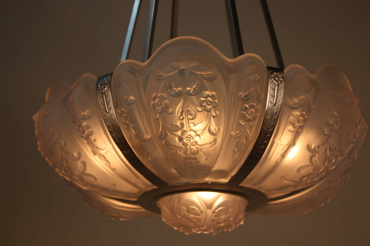 A great Art Deco chandelier. Made in France circa turn of the century, this piece was crafted with nickel on bronze and seven molded glass shades.