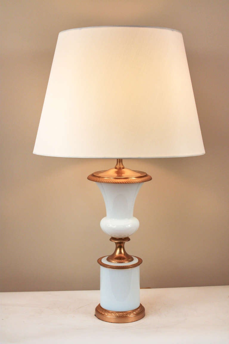 A beautiful 1950's modern-influenced table lamp. Originally crafted in France, this stunning lamp is made of elegant white opalescent glass, and features exquisite bronze mounting.