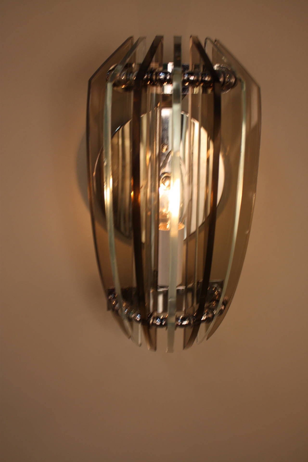 Simple but very chic wall sconces in clear and smoked glass by Veca.