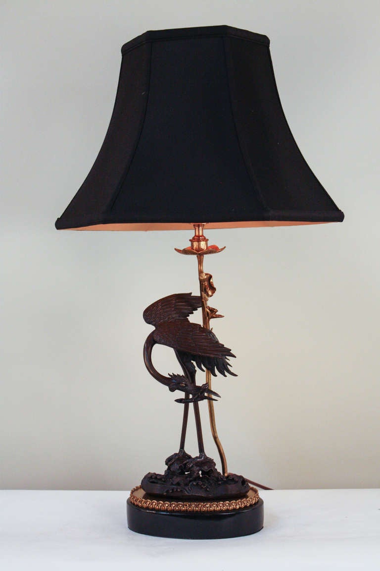 This unique and gorgeous table lamp dramatically depicts a perched dragon with superb detail work. Beautiful two color bronze and a black lacquer base give this piece an elegant atmosphere.