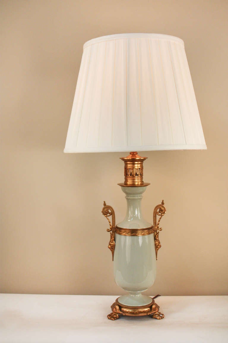 Elegant, yet simple, this table lamp is truly beautiful. Crafted in France during the 1800's, this lamp originally burned oil, and has been professionally electrified. Made of gorgeous celedon porcelain, this table lamp features ornately detailed
