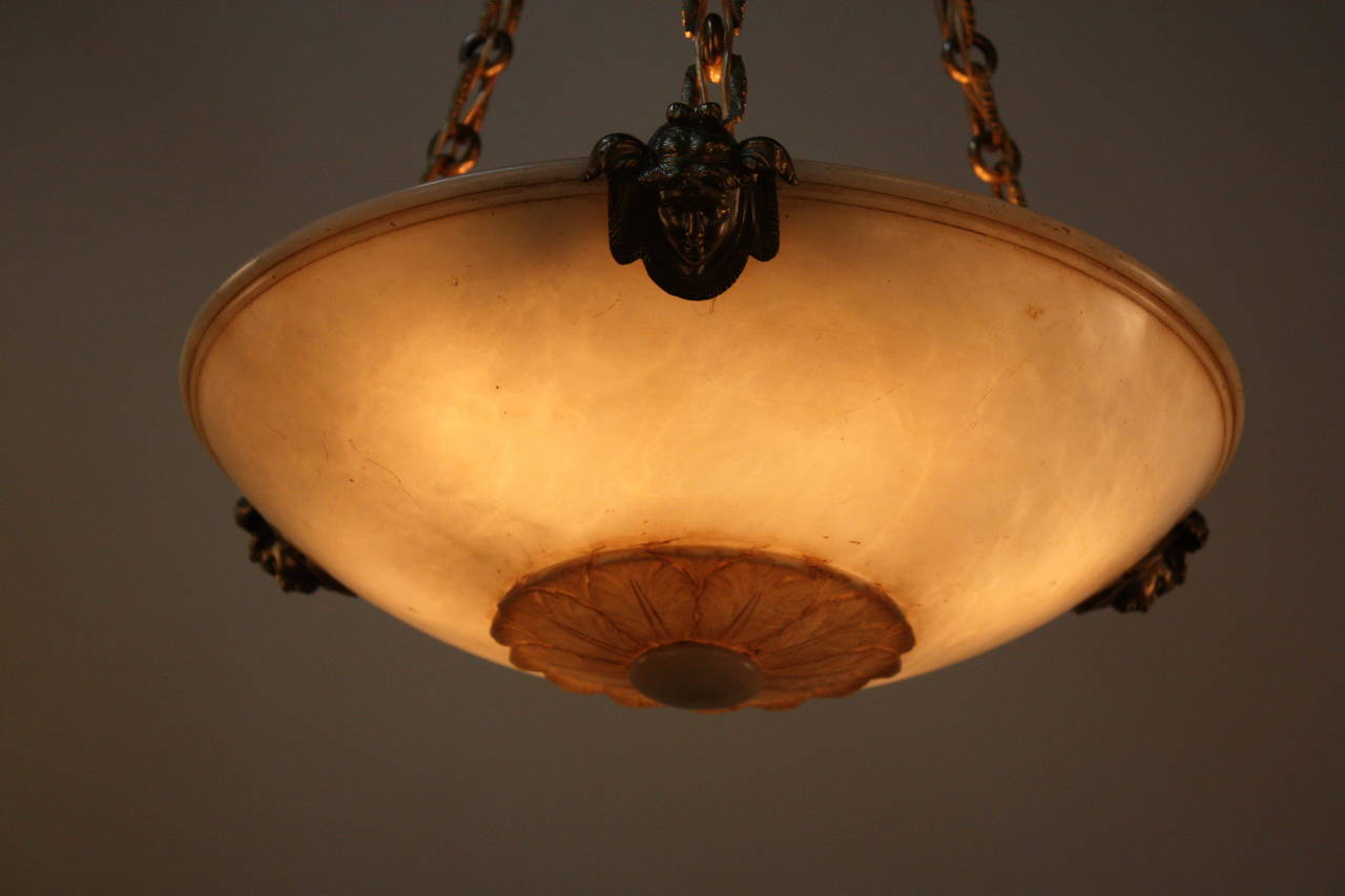 Fabulous alabaster chandelier with carved flora center design witted with elegant bronze and neoclassical hardware.