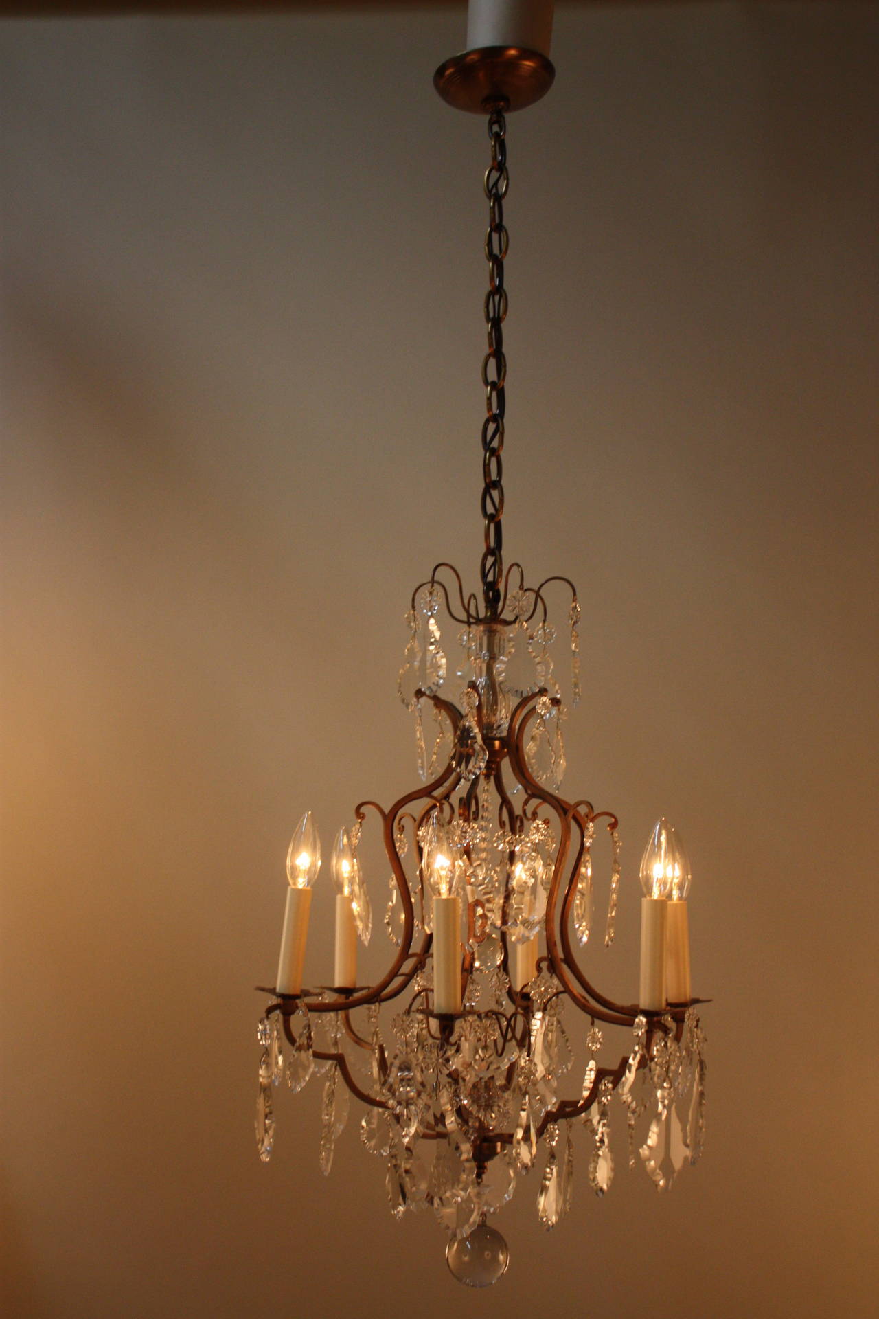 Made in France during the 1920s, this beautiful six-light chandelier features a Classic bronze design and elegant hanging crystals.