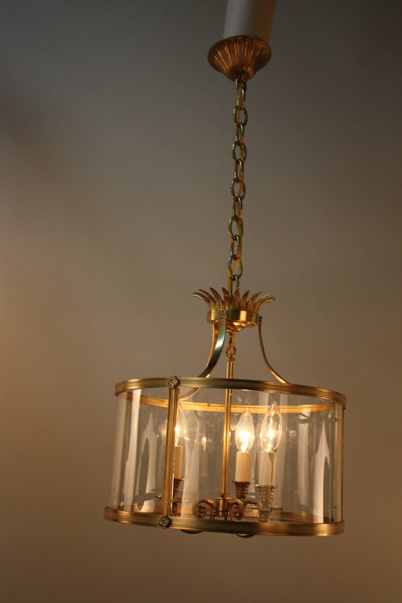 Made in France during the 1950s, this bronze lantern is exceptionally beautiful. Three candelabra style lights elegantly illuminate this lantern's breathtaking detail work. An absolutely superb lantern.