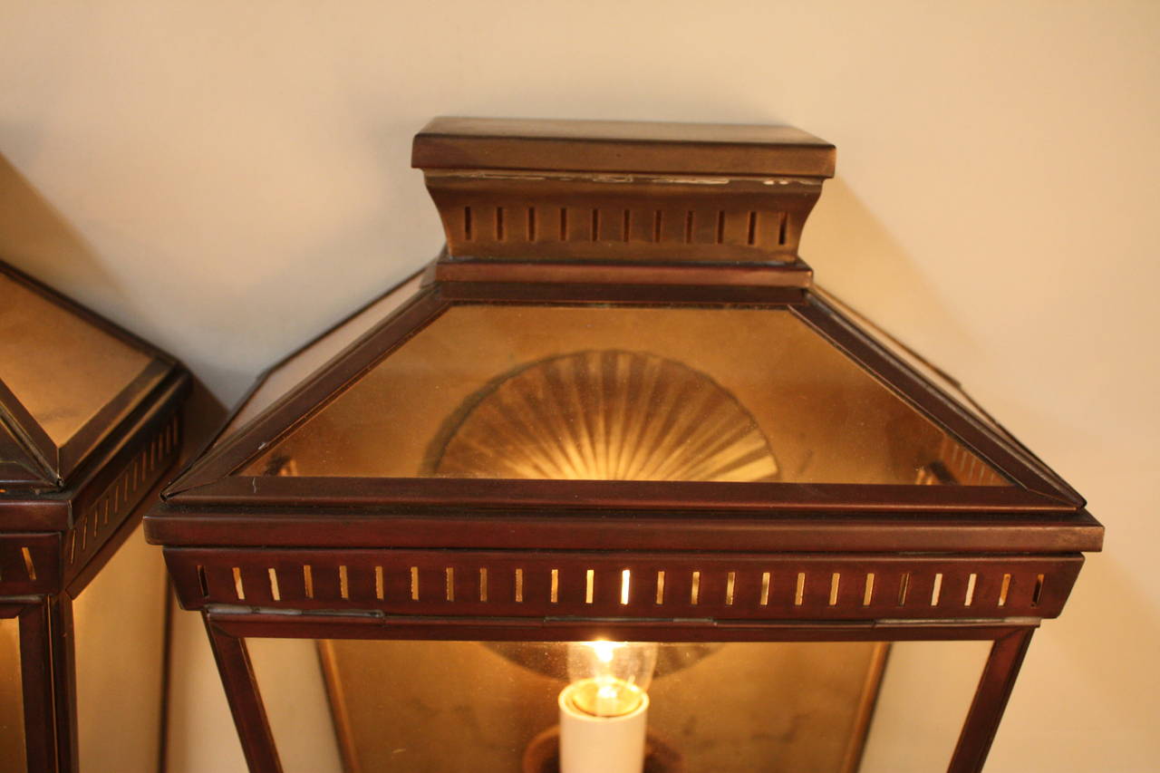 Wonderful pair of 1950s French bronze wall lanterns with beautiful brown and red patina.