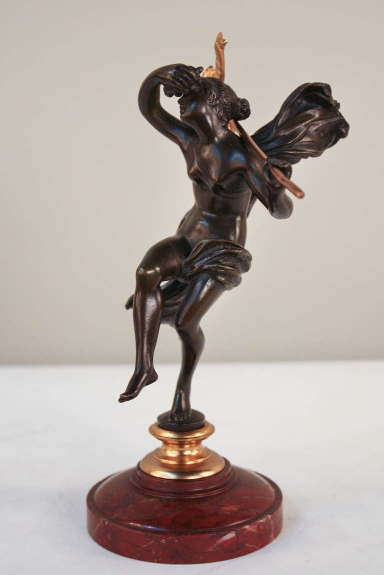 A stunning sculpture. Masterfully crafted in 19th century France, this elegant two color bronze depicts a beautiful young woman dancing atop a red marble base. Full of fabulous detail work, the subject appears almost frozen in time, her dress