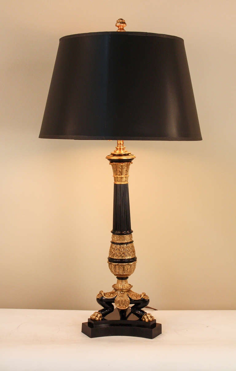 A classic example of elegant European craftsmanship and artistry, this 19th c. Empire table lamp is truly something special. 

Made of beautiful black lacquer on bronze, this timeless table lamp is filled from top to bottom with ornate detail