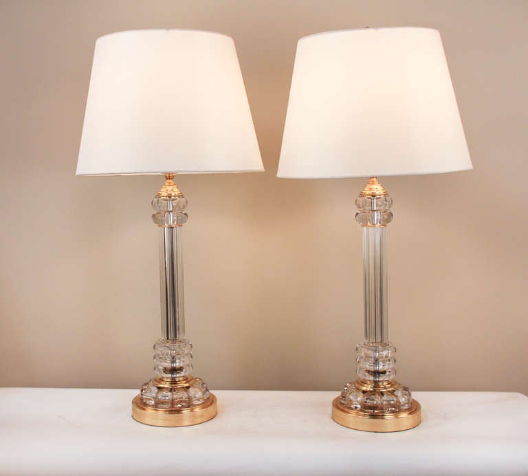 Made by the world renowned designers at Paul Hanson New York, these timeless 1950's table lamps look as stunning today as they did half a century ago. Made of gorgeous glass, this elegant pair features a beautiful brass bases and tops.