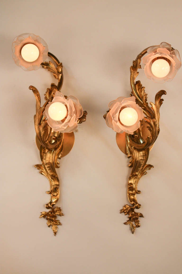 An beautiful pair of wall sconces. Masterfully crafted in France during the early 1920's, these wonderful sconces feature an unmistakable organically-influenced heavily Art Nouveau design. Made of ornately detailed  bronze, these double light