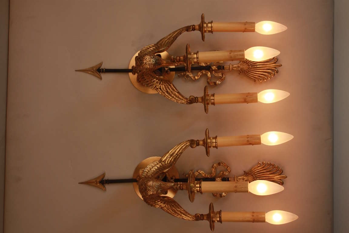 A fantastic pair of three light empire style wall sconces. Made in France, these elegant sconces feature beautiful detail work throughout. Absolutely gorgeous.