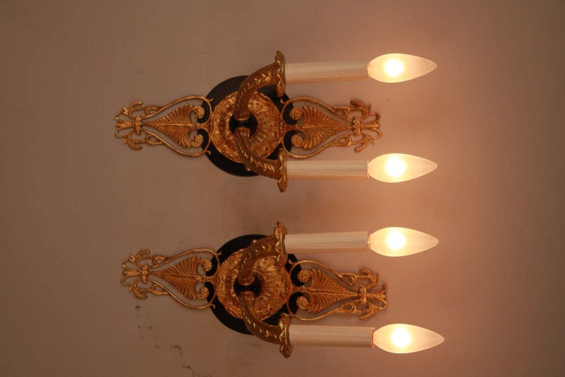 A fabulous pair of double light Empire Style wall sconces. Made in France during the 1920's, these elegant fixtures are made of beautiful bronze and feature gorgeous detail work.