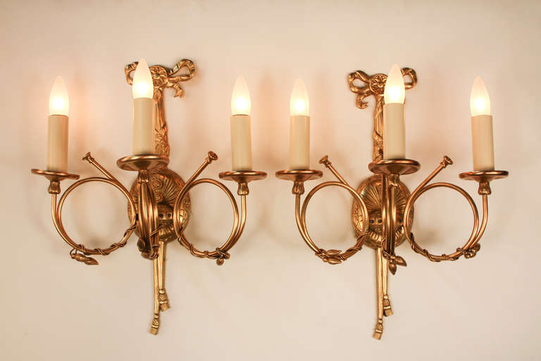 An elegant pair of three light wall sconces. Artisanally crafted in Spain during the 1930's, these gorgeous sconces feature fabulous bronze detail work: beautiful examples of fantastic traditional European artistry and craftsmanship.