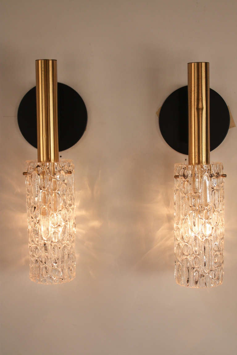 Crafted in France during the 1970s, this pair of wall sconces elegantly combines modernist design with classic influences.

The sconce's beautiful brass and black lacquer harken back to the timeless color scheme representative of antique French