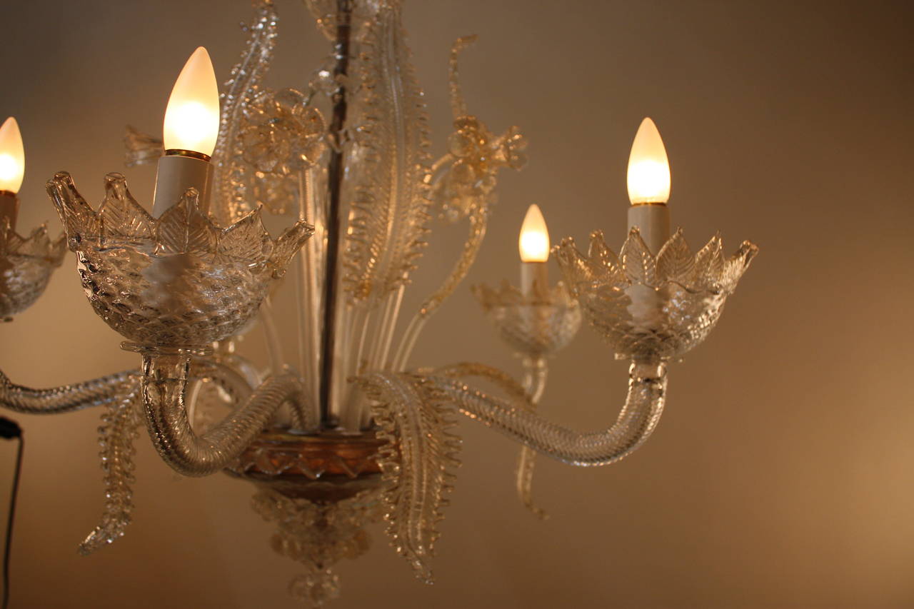 A handblown Venetian chandelier in clear glass and touch of gold which shows mastery of artisan glass blower.