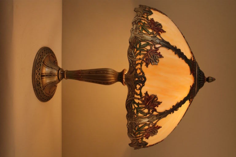 AMERICAN ART NOUVEAU STAINED GLASS LAMP WITH BENT CARAMEL COLOR GLASS ,BASE AND FRAME IS ANTIQUE SILVER PLATE WITH COLD PAINT DECORATION ,<br />
NEWLY REWIRED