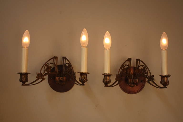 A fantastic pair of adjustable arm piano lamps. In the 1800's, these lamps were mounted on the sides of a piano, and candles were used to illuminate sheet music. Since then, the fixtures have been custom converted to wall sconces and electrified,