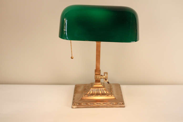 A classic piece of Americana, this beautiful Emeralite desk lamp was originally made in 1916. This superb lamp features a beautiful brass base, a fabric covered cord. A versatile piece, the lamp is adjustable from the top and the base. 

The