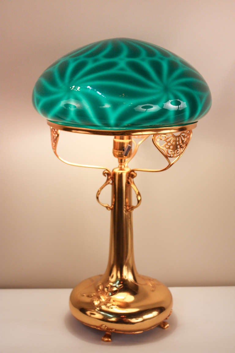 Elegant and unique; this fabulous gold plated table lamp features a rare green glass shade.