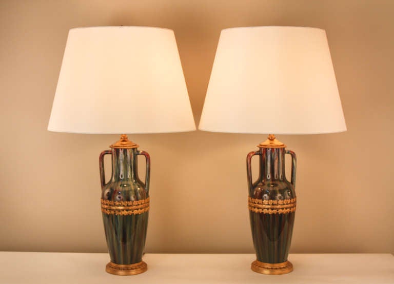 Made of French pottery and accented with bronze, these gorgeous table lamps are not to be missed. The simplicity of the pottery is complemented by the fine floral details in the bronze design, making for a truly unique piece. These lamps have been