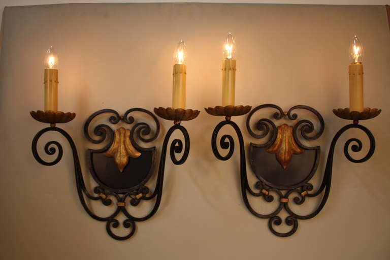 A fabulous pair of double-arm wall sconces. Crafted in France during the 1930s, these sconces feature an excellent artisanal iron design.