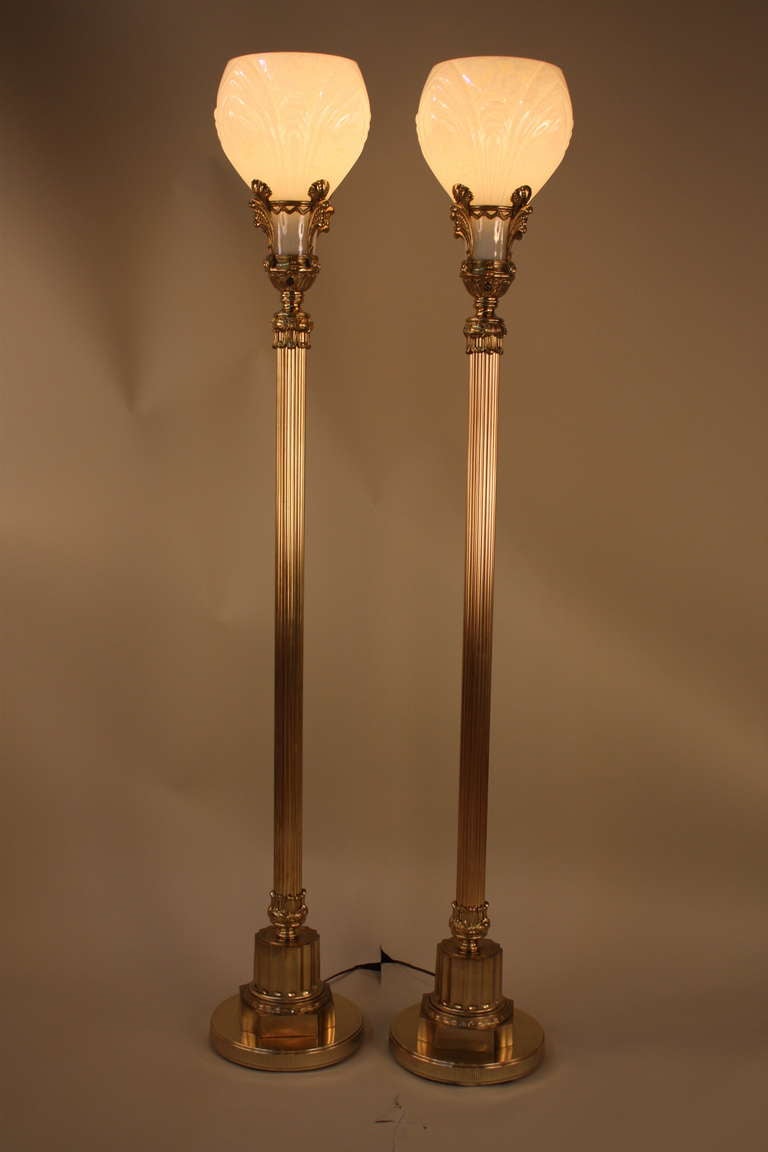 An elegant pair of American Art Deco torchiere floor lamps with white pear colored tulip shaped glass shades.