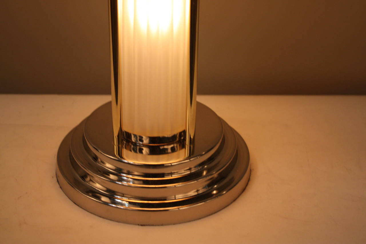 Fabulous French Art Deco table lamp in great combination of polish nickel and bronze with light in the center of glass column as well as under the dome shade.