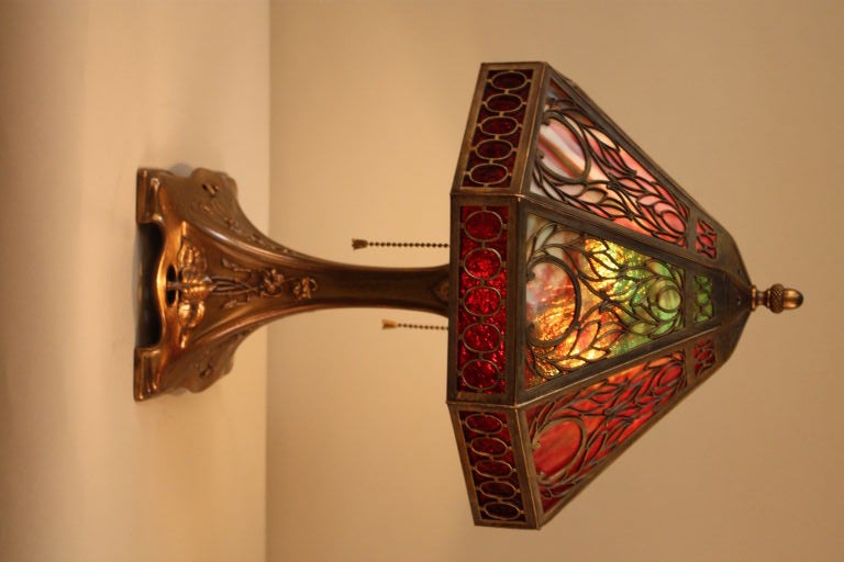 AMERICAN COLORFUL ART NOUVEAU EIGHT PANEL SLAG GLASS LAMP WITH BRONZE FINISHED BASE.