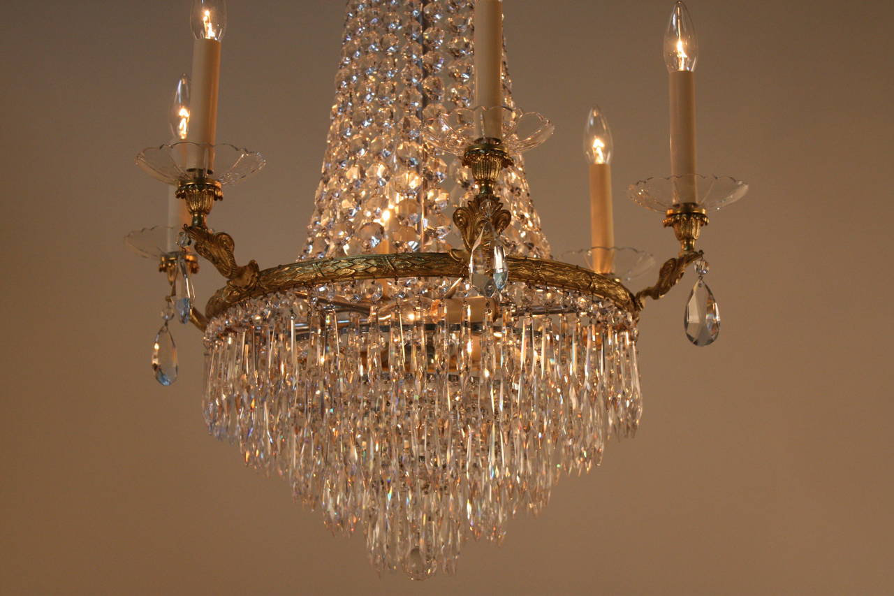 Elegant twelve-light Empire style crystal and bronze chandelier. 
The minimum height completely installed is 36