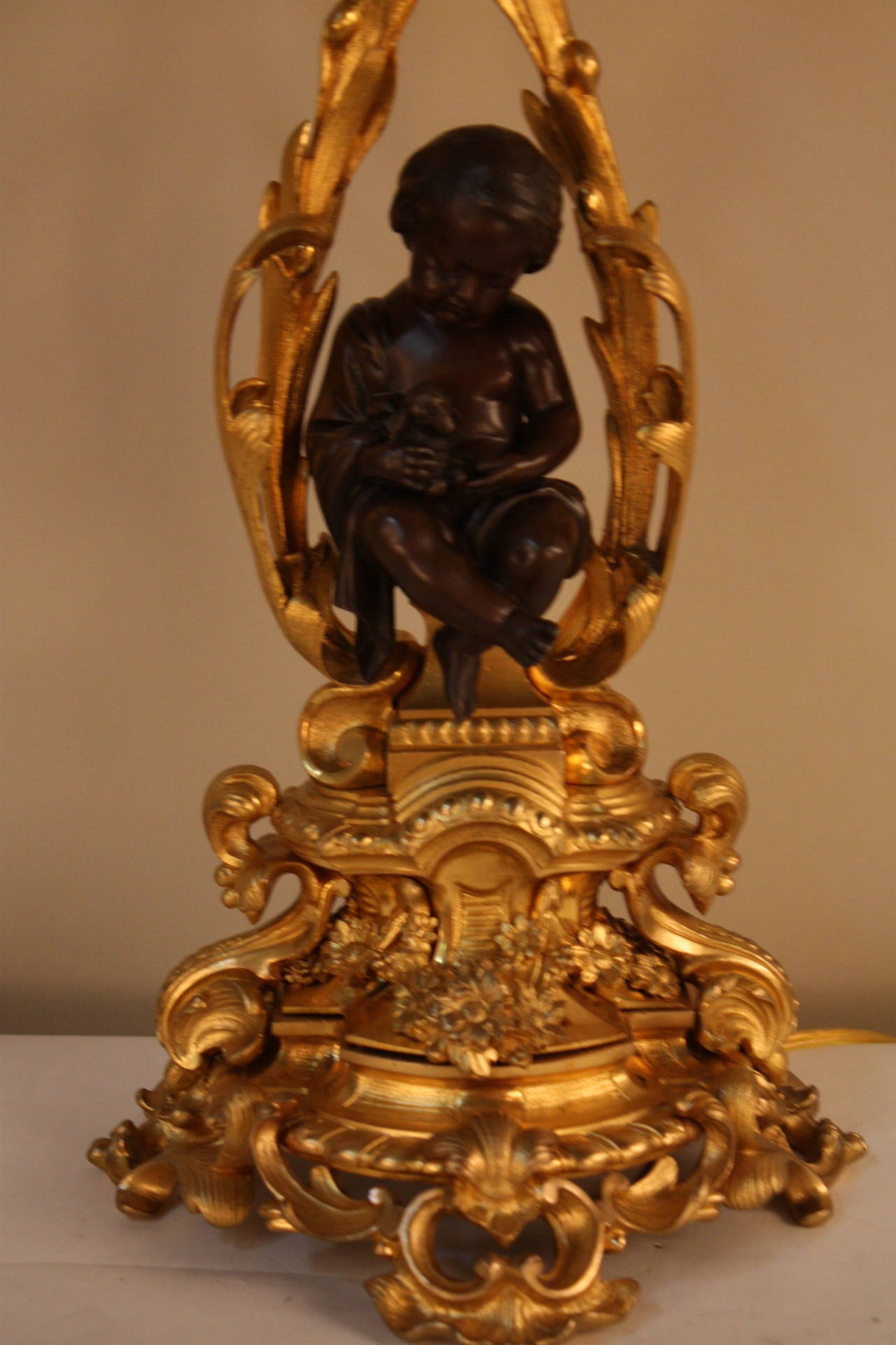 A magnificent electrified 19th century seven-light doré bronze candelabra lamps with figural cherub.