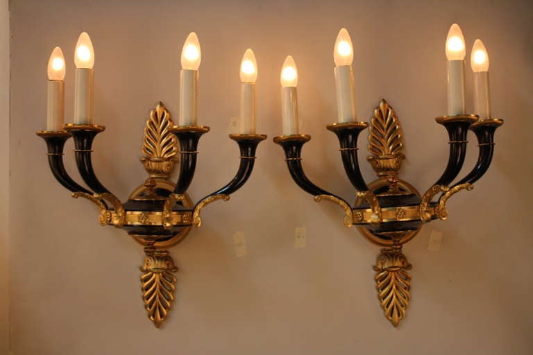 An elegant pair of four-light wall sconces. Crafted in France during the 1930s, these beautiful sconces are made of solid bronze.