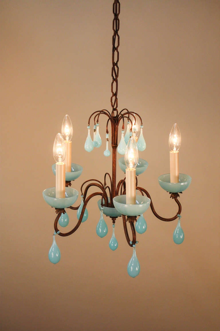 Made in Italy during the 1950s, this chandelier features an oxidized gold leaf body that has aged wonderfully, giving the entire fixture a beautiful patina. <br />
<br />
Accenting the body of the chandelier, dozens of blue colored blown glass