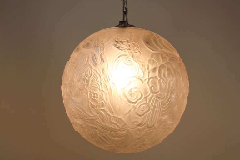 This beautiful piece is a large globe, French Art Deco chandelier. It has a single light, but can be used with a very strong light bulb. The glass has fantastic natural designs such as flowers and a bird, and the piece is finished with a hand-forged
