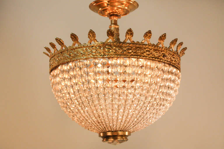 This 4-light Spanish piece features a crystal basket with beading. The bronze mount features an intricately detailed geometric pattern as well.